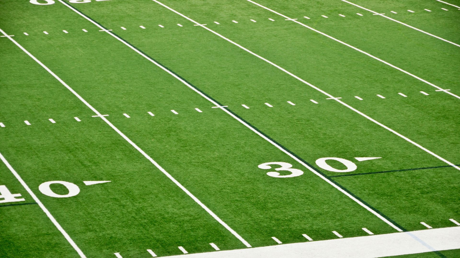 Football field prepared for game day under stadium lights